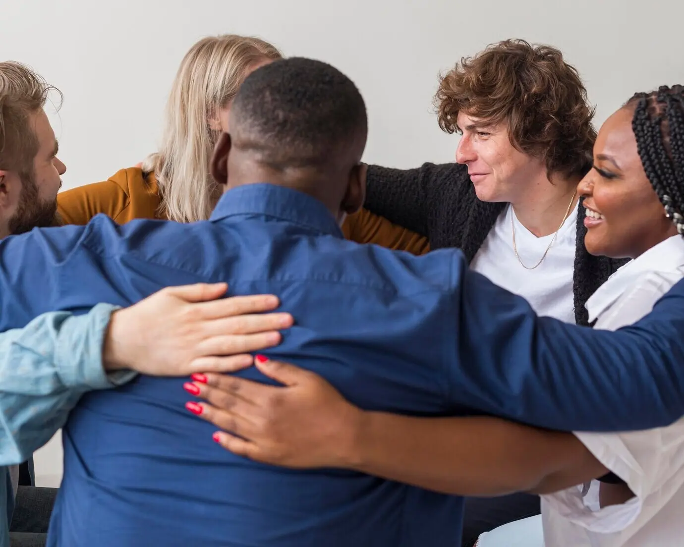 Крупный план людей, обнимающихся в помещении.